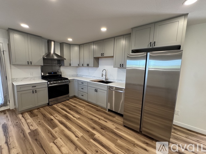 A kitchen with wooden floors and stainless steel appliances.