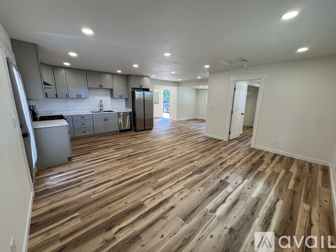 A kitchen with wooden floors and white walls.