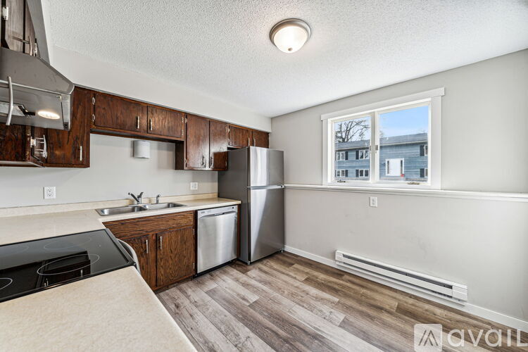 A kitchen with wooden cabinets and a stainless steel refrigerator.