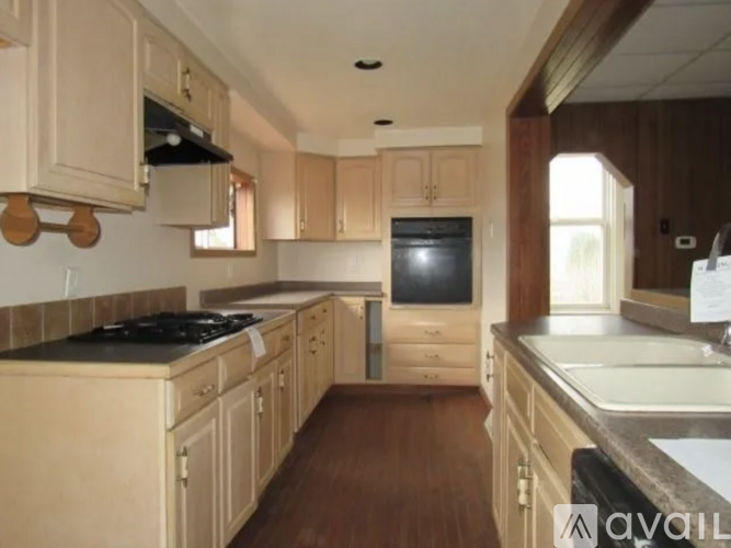 A kitchen with wooden cabinets and a black stove top.