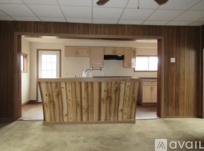 A wooden kitchen island in a room with wooden walls.
