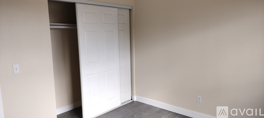 A room with a white door and a grey floor.