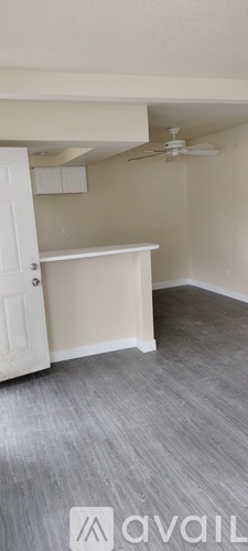 A room with a ceiling fan and a white door.
