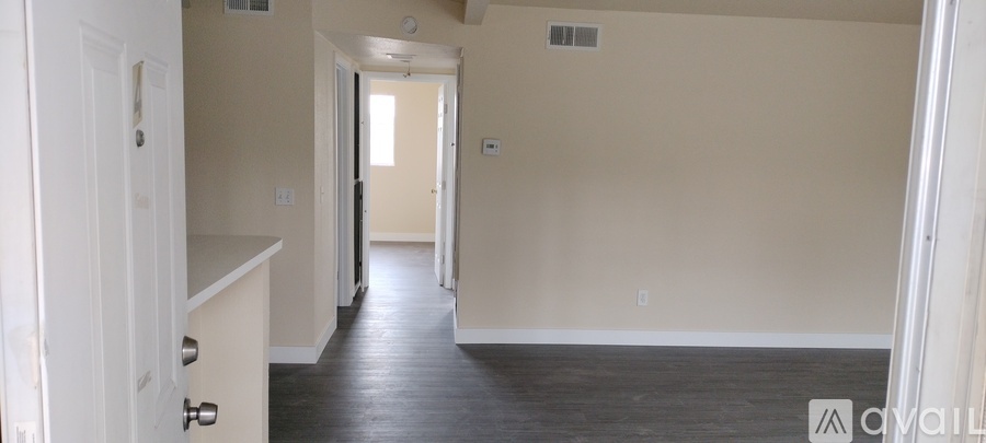 A long hallway with a door on the left and a door on the right.