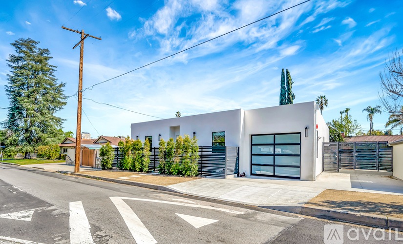 A modern house with a white exterior and a garage door is for sale.