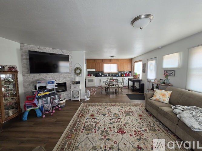 A living room with a couch, a television, and a fireplace.