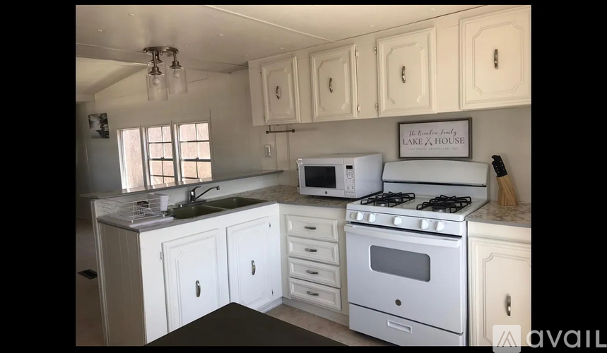 A kitchen with white appliances and cabinets.
