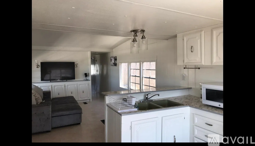 A kitchen with white cabinets and a black countertop.