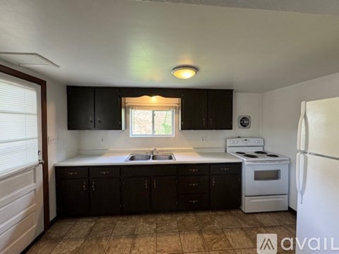 A kitchen with black cabinets and white appliances.
