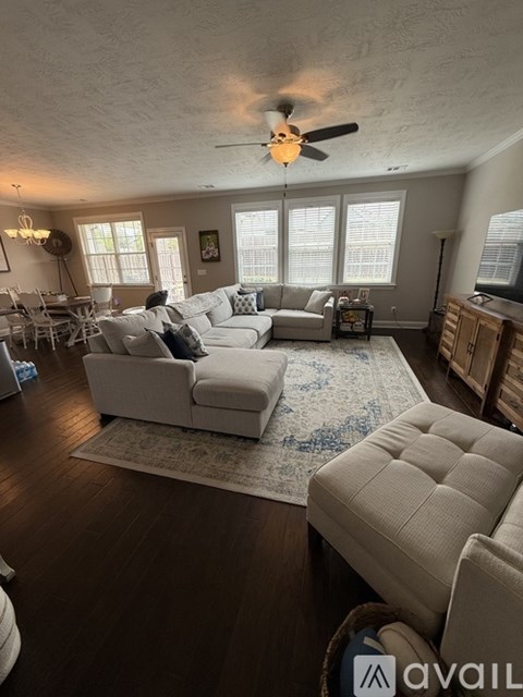 A living room with a white couch and a rug.