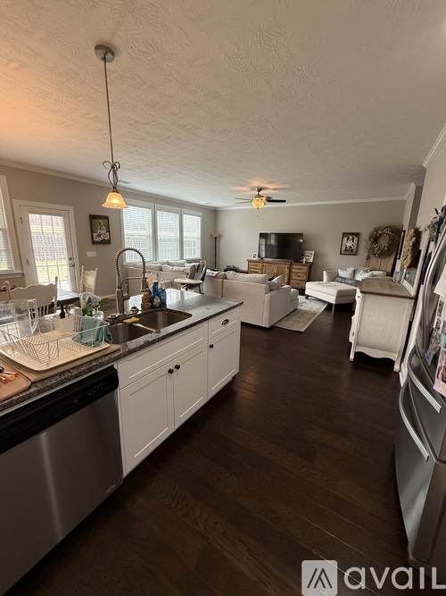 A kitchen with white cabinets and a wooden floor.