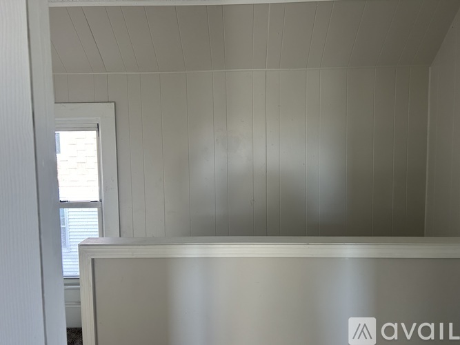 A white room with a window and a white wall.