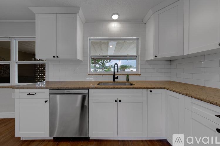 A kitchen with white cabinets and a wooden countertop.