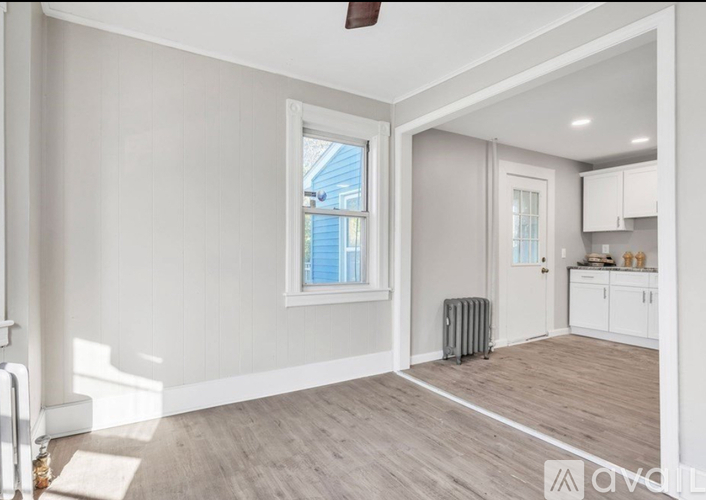 A room with a window, a door, and a ceiling fan.
