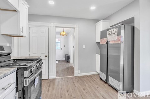 A kitchen with a stove top oven and a refrigerator.