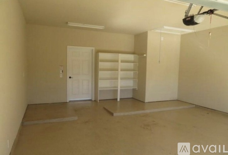 A room with a white door and a fan on the ceiling.