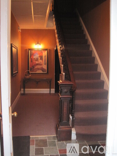 A staircase with a light on the wall.
