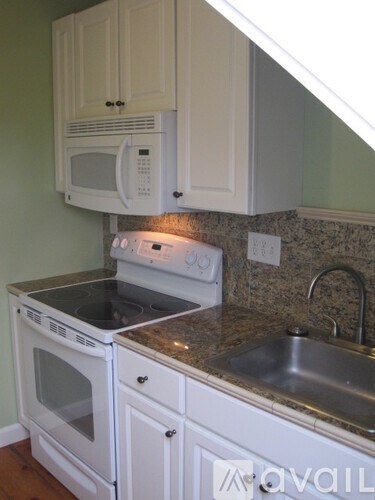 A kitchen with white appliances and cabinets.
