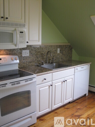 A kitchen with white appliances and cabinets.