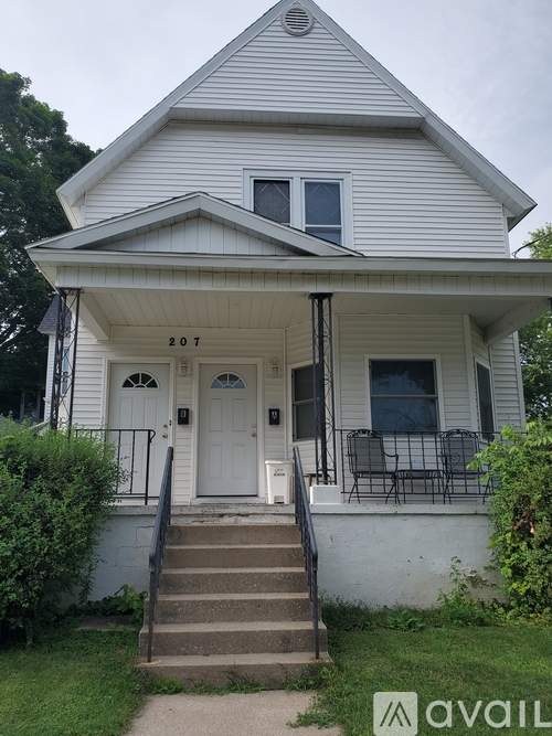 A white house with the number 207 on the front door.