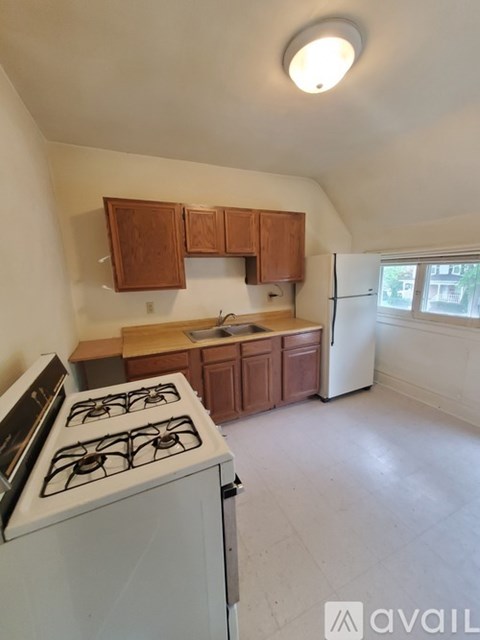 A kitchen with a white stove and wooden cabinets.