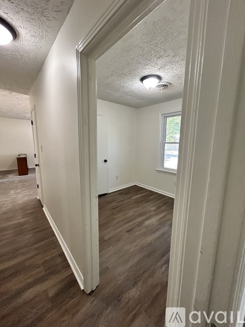 A room with wooden flooring and white walls.