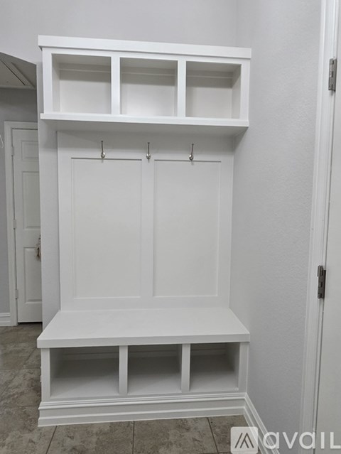 A white built-in bench and shelves in a room.