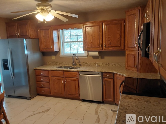 A kitchen with wooden cabinets and a stainless steel refrigerator.