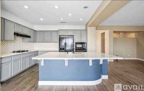 A kitchen with a blue island in the middle.