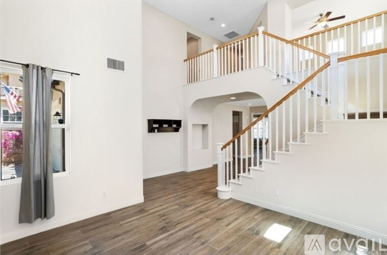 A large open space with a staircase and a ceiling fan.
