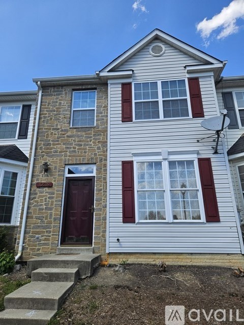 A two-story house with a red door and white siding.