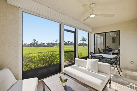 A living room with a white couch and a ceiling fan.