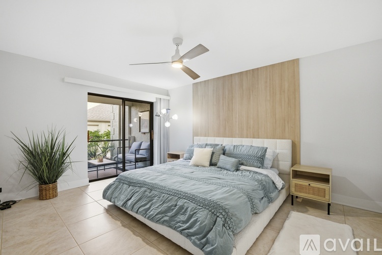 A bedroom with a large bed and a ceiling fan.