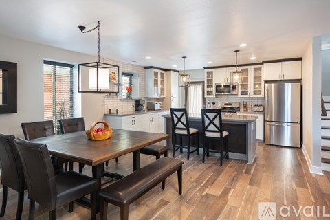 A modern kitchen with a dining table and chairs.