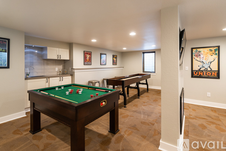 A pool table in a room with a TV and a painting on the wall.