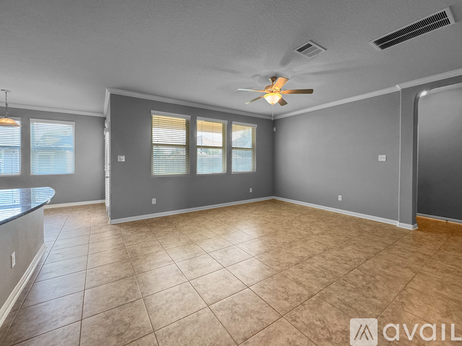A spacious room with a ceiling fan and tiled flooring.