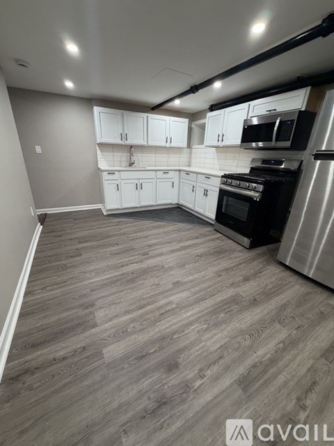 A kitchen with white cabinets and a black stove top oven.