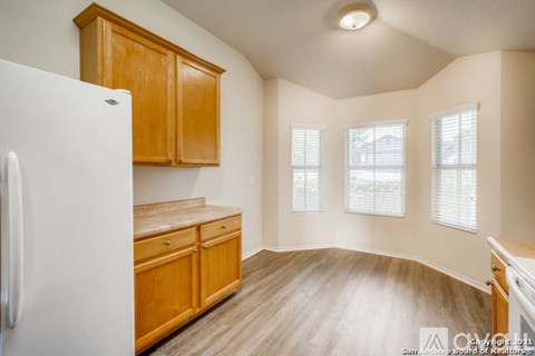A kitchen with wooden cabinets and a white refrigerator.