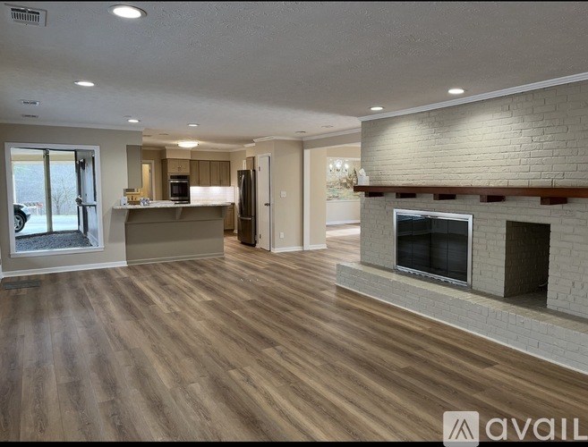 A spacious living room with a fireplace and hardwood floors.