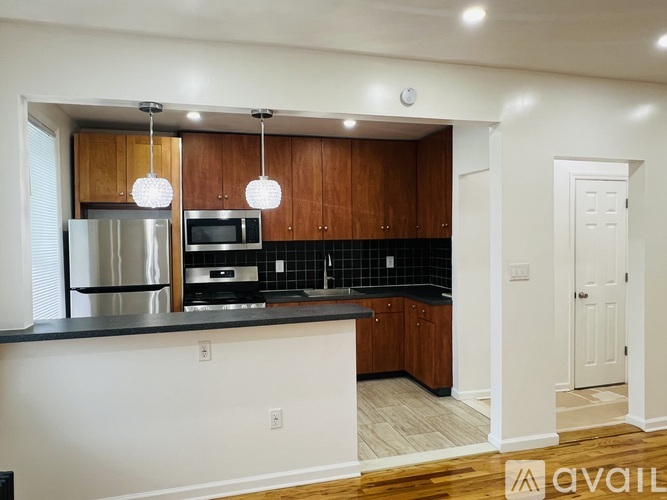 A kitchen with wooden cabinets and a black countertop.