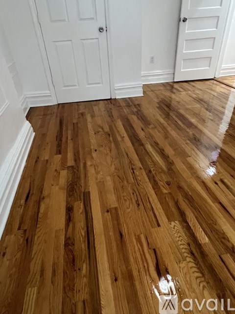 A room with a wooden floor and white doors.