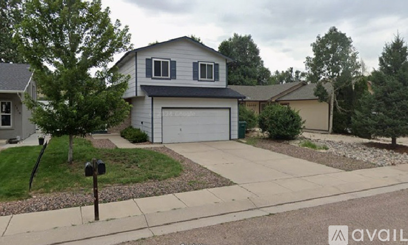 A house with a grey garage door is available for sale.