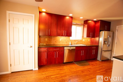A kitchen with red cabinets and a white door.