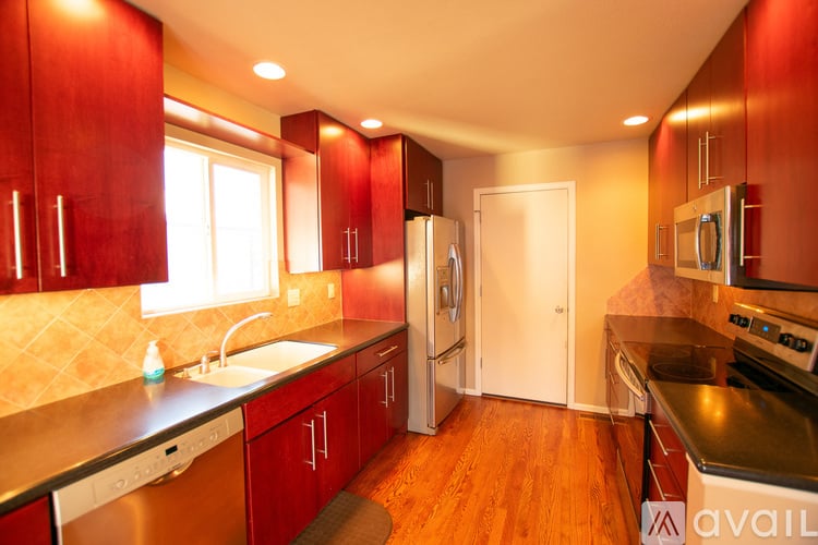 A kitchen with red cabinets and a white door.