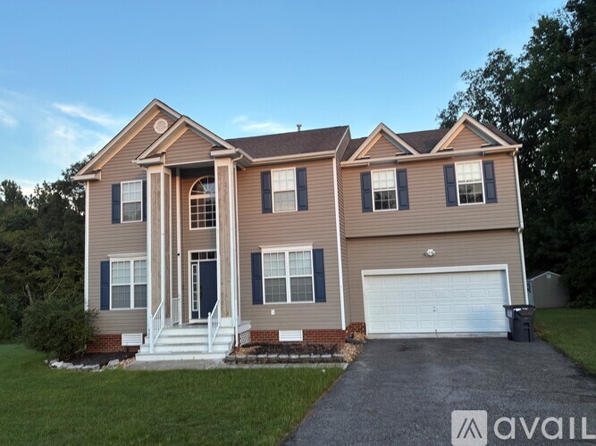 A two-story house with a garage and a driveway.