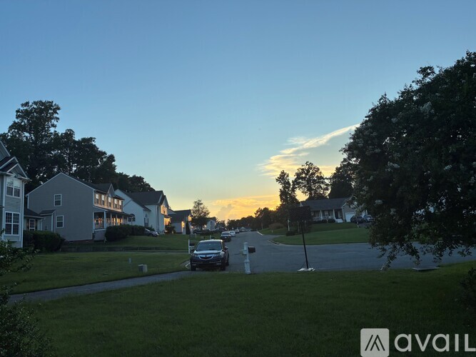 A car is parked on a street with houses on both sides.