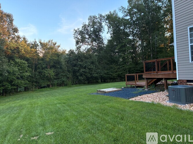 A backyard with a deck and a hot tub.