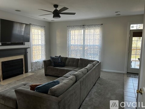 A living room with a grey couch and a fireplace.