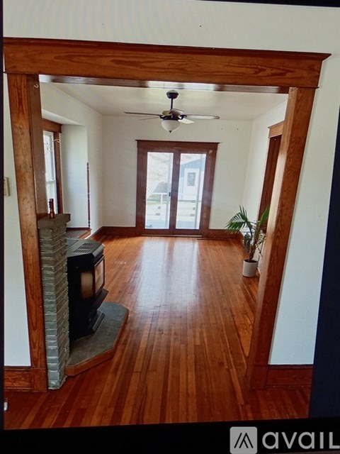 A living room with wood floors and a fireplace.