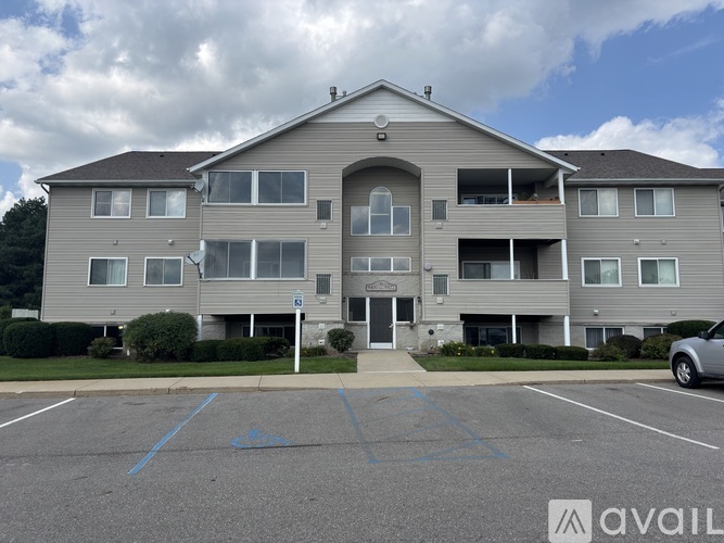 A large apartment building with a parking lot in front.